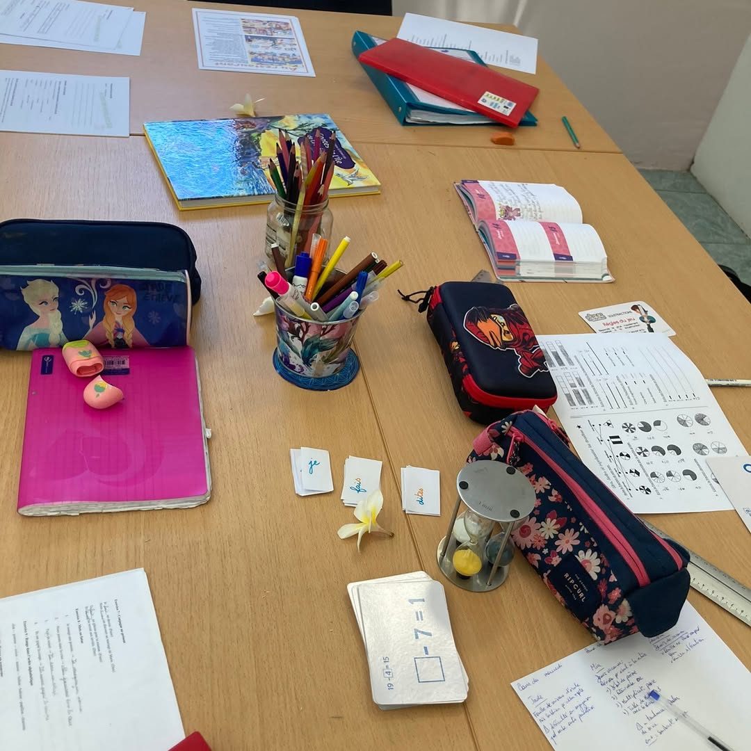 Table de travail du centre avec cahiers, trousses, crayons et cartes de lecture