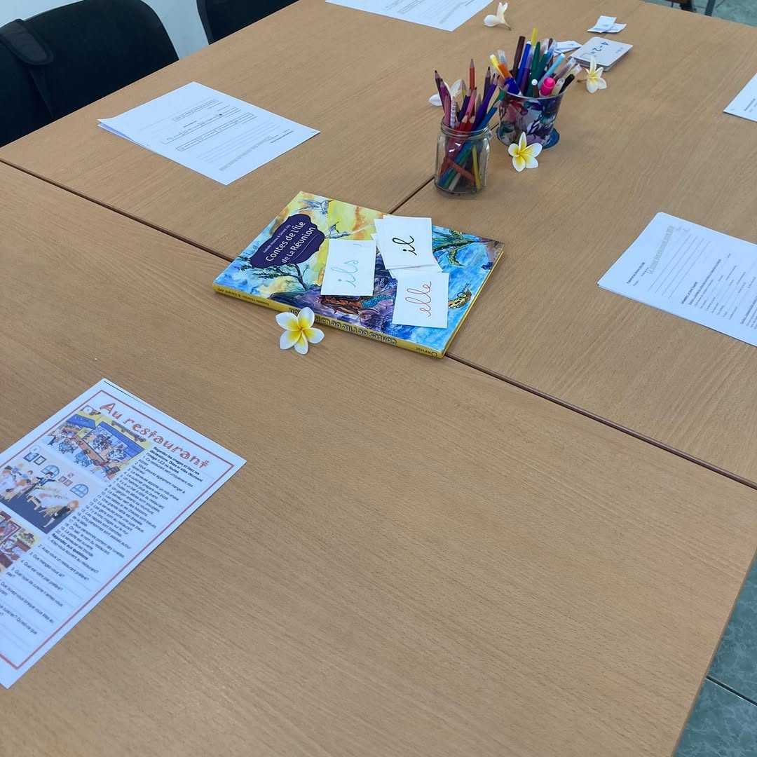Table du centre avec cartes de syllabes, crayons et un livre de lecture