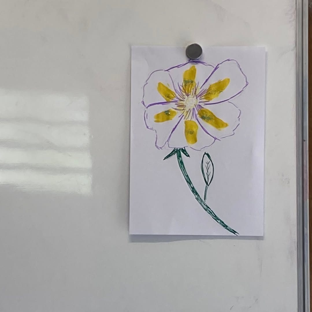 Dessin de fleur réalisé par un enfant, affiché au tableau